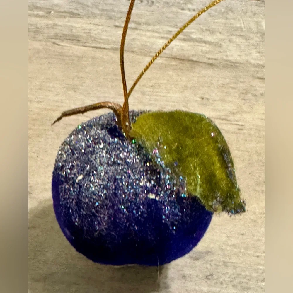 Christmas tree ornament. A plum-shaped ornament covered in glitter. The ornament